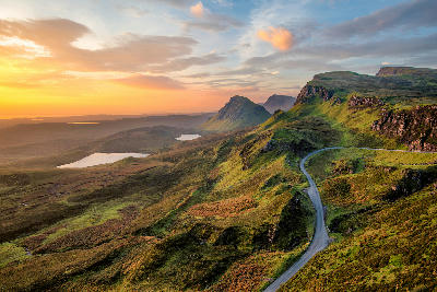 Vibrant sunrise over the Quiraing on the Isle of Skye, with layered ridges and dramatic rock formations in soft morning light.