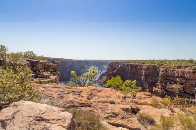 View across the rugged sandstone plateau into the deep King George River gorge, with red cliffs and sparse Kimberley vegetation.