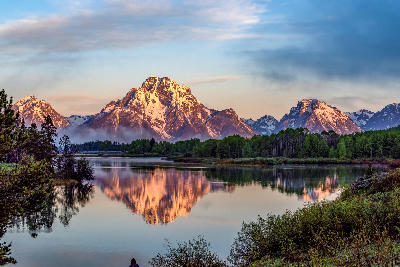 Teton Range reflected in a calm river at sunrise, Grand Teton National Park.