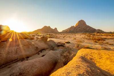 Sunrise light over the granite peaks and desert landscape of Spitzkoppe in Namibia.