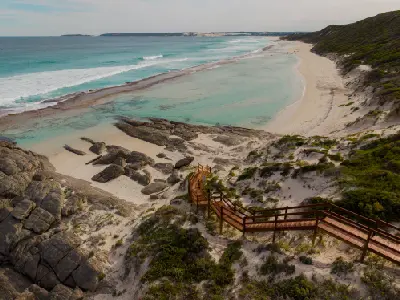 Wooden staircase descending to Eleven Mile Beach with white sand, turquoise water and coastal dunes near Esperance, Western Australia.