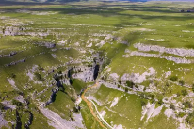 Aerial photograph of Gordale Scar showing steep limestone cliffs, a narrow rocky gorge and a winding footpath near Malham, North Yorkshire.