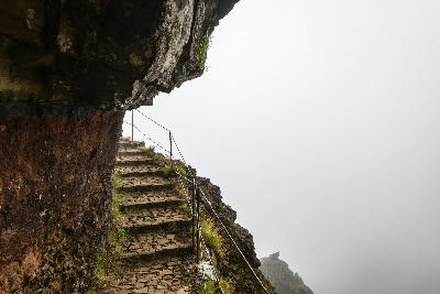 Cliffside stone stairway on the PR1 Vereda do Areeiro hiking trail near Pico do Areeiro, Madeira, Portugal.