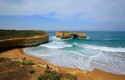 London Arch and surrounding beach and limestone cliffs in Port Campbell National Park, Victoria.