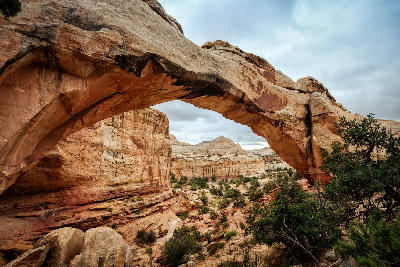 Natural sandstone arch of Hickman Bridge above desert canyon in Capitol Reef National Park Utah