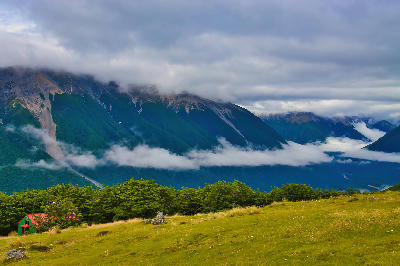 Bushline Hut on Mount Robert overlooking the St Arnaud Range with clouds in the valley in Nelson Lakes National Park.