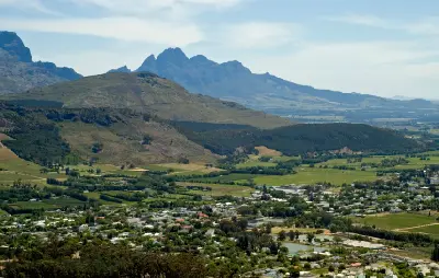 Elevated view of Franschhoek Village, vineyards, and mountain landscape from Franschhoek Pass in the Western Cape, South Africa.