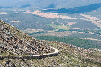 Mountain road descending along Swartberg Pass above the Klein Karoo valley in the Western Cape, South Africa.