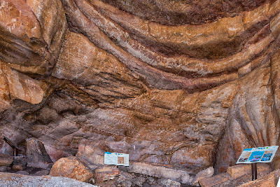 Sandstone rock shelter with ancient San rock art and interpretive signage along the Sevilla Rock Art Trail in the Cederberg Mountains, South Africa.
