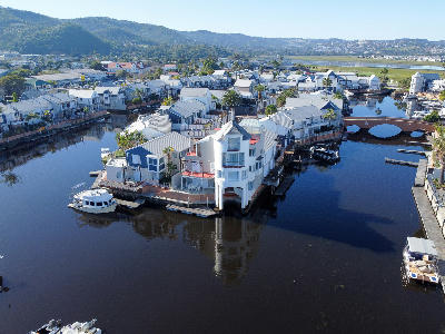Aerial view of Thesen Island with waterfront houses, canals, private docks, boats and a pedestrian bridge in Knysna Lagoon, South Africa.