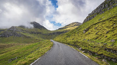 Narrow mountain road leading toward Slættaratindur above Funningur on Eysturoy, Faroe Islands.