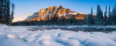 Castle Mountain at sunrise with snow and Bow River in Banff National Park, Alberta, Canada