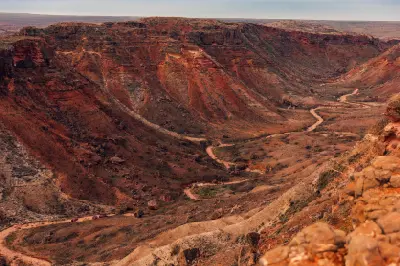 Winding road through the dramatic red-rock walls and rugged slopes of Charles Knife Canyon.