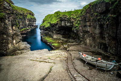 Rocky sea gorge forming the natural harbour at Gjógv village on Eysturoy, Faroe Islands.