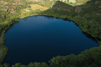 Aerial view of Diamond Lake surrounded by forested hills near Wānaka, Otago, South Island, New Zealand.
