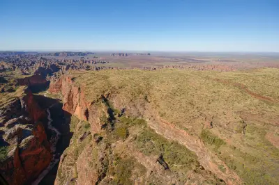 Sweeping aerial view across deep sandstone gorges, rugged ridges and the vast outback landscape of Purnululu National Park.