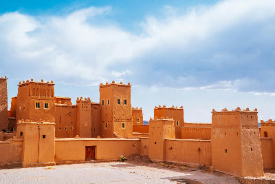 Kasbah Taourirt fortified mud-brick architecture in southern Morocco beneath dramatic desert skies and traditional kasbah towers