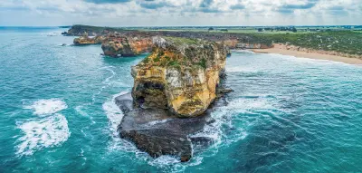 Aerial close-up of a large eroded limestone formation and wave-cut rock platform at Childers Cove, Victoria.