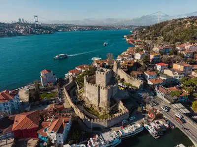 Aerial view of Anadolu Hisarı on the Bosphorus with ferries and the Fatih Sultan Mehmet Bridge in Istanbul, Turkey.