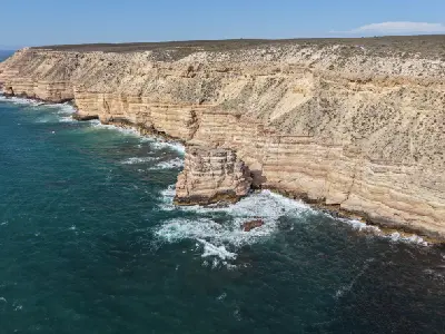 Aerial view of layered coastal cliffs and Island Rock above the Indian Ocean in Kalbarri National Park.