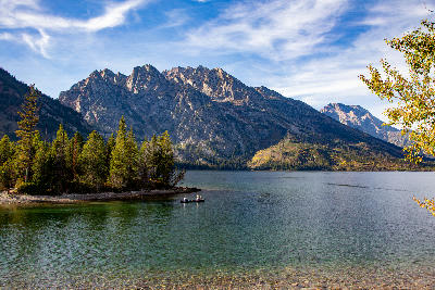 Jenny Lake with clear water, small boat, and the Teton Range in the background, Grand Teton National Park, Wyoming, USA.