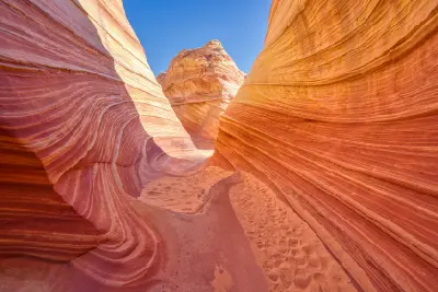 Curved layered sandstone walls and sandy path within The Wave Coyote Buttes North Arizona