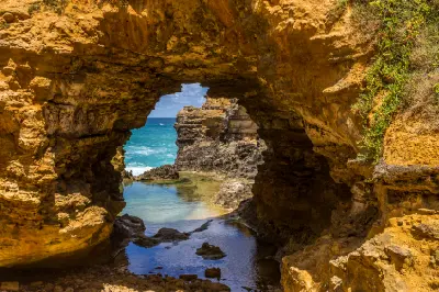 Golden limestone arch and rock pool overlooking the ocean at The Grotto, Victoria.