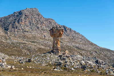 The Maltese Cross sandstone rock formation standing beneath mountain slopes in the Cederberg Wilderness, Western Cape, South Africa.