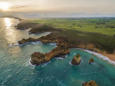 Aerial view of Childers Cove coastline with limestone headlands, offshore rocks, turquoise ocean and farmland in Victoria.