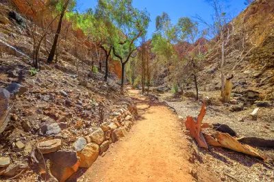 Sandy walking trail winding through eucalyptus trees and rocky slopes on the approach to Standley Chasm.