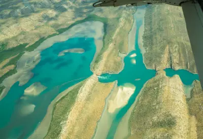 Scenic-flight view over Horizontal Falls, with turquoise tidal water surging through a narrow gap among the rugged islands and channels of the Buccaneer Archipelago.