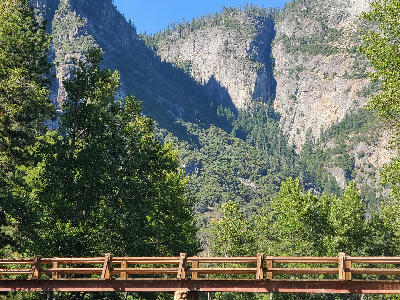 Sentinel Bridge over the Merced River with trees and granite valley walls in Yosemite National Park.