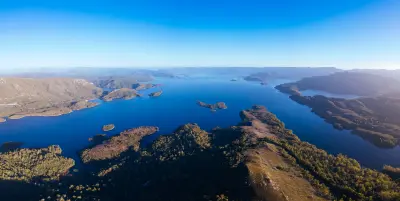 Expansive aerial view of Lake Pedder surrounded by rugged mountains and wilderness in southwest Tasmania.