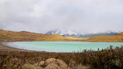Turquoise waters of Laguna Amarga with cloudy mountains in Torres del Paine National Park, Chile.