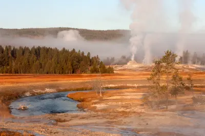 Firehole River winding toward steaming geysers Upper Geyser Basin Yellowstone