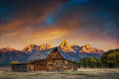 Moulton Barn with the Teton Range glowing in sunset light behind it, Mormon Row, Grand Teton National Park, Wyoming.