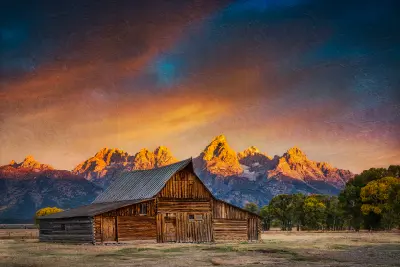 Moulton Barn with the Teton Range glowing in sunset light behind it, Mormon Row, Grand Teton National Park, Wyoming.