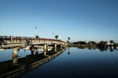 Bridge over Milnerton Lagoon with Woodbridge Island lighthouse in the background, Cape Town, South Africa.