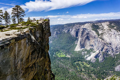 Taft Point cliff edge with people overlooking Yosemite Valley, El Capitan and the Merced River in Yosemite National Park, California.