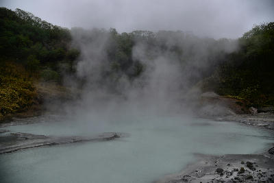Steam rising over milky sulphur water at Oyunuma Pond in Noboribetsu, Hokkaido, Japan.