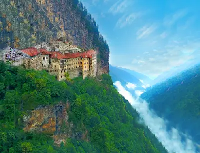 Sümela Monastery built into a dramatic forested cliff overlooking the misty Altındere Valley in Trabzon Province, Turkey.