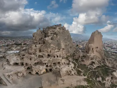 Aerial view of Uçhisar Castle with rock-cut caves and surrounding volcanic formations in Cappadocia, Turkey.