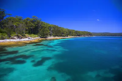 Clear turquoise and deep blue water fringes the bushland shoreline at Hyams Beach in Jervis Bay.