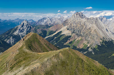 High alpine ridge with layered mountain peaks and rugged rock formations in Kananaskis Country, Alberta, Canada.