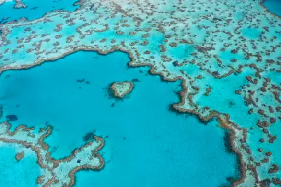 Aerial view of Heart Reef surrounded by coral formations and turquoise water in the Great Barrier Reef, Queensland.