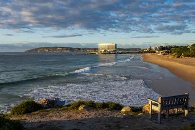 Central Beach in Plettenberg Bay looking towards Beacon Isle, with sandy shoreline, breaking waves and coastal views across the bay.