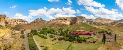 Panoramic view of Golden Gate Highlands National Park with sandstone cliffs, grassland valleys, mountain roads and accommodation nestled beneath the Maloti foothills.