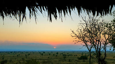 Sun rising above the Mkata Floodplain seen from a thatched safari lodge in Mikumi National Park.