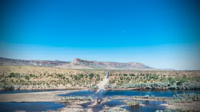 Aerial view of the Pentecost River crossing with a four-wheel-drive in the shallow water and the Cockburn Range rising beyond.