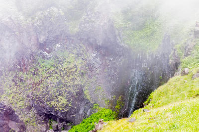 Furepe Waterfall flowing down a concave basalt cliff in Shiretoko, Hokkaido